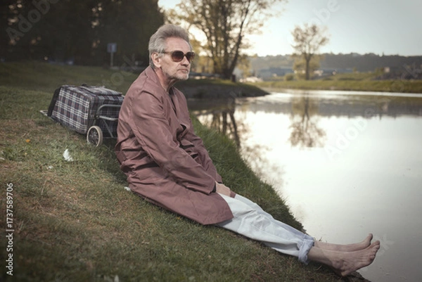 Fototapeta Senior citizen spending time alone in spring park with cart