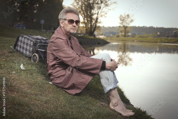 Fototapeta Senior citizen spending time alone in spring park with cart