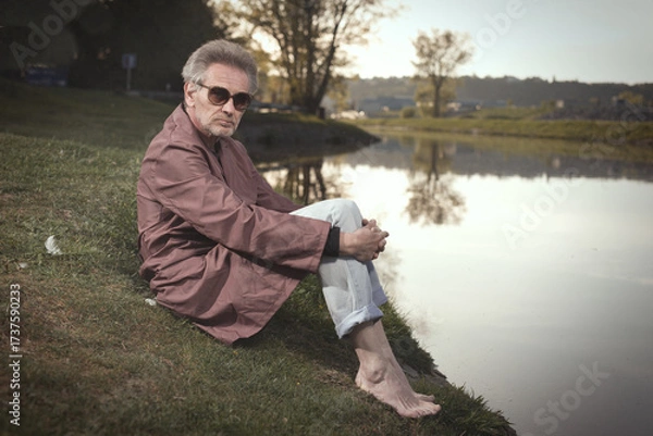 Fototapeta Senior citizen spending time alone in spring park with cart