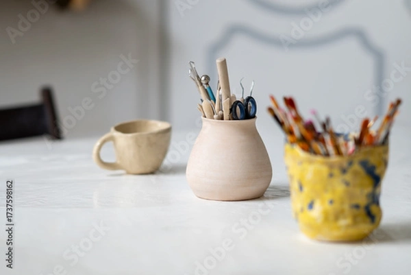 Obraz Brushes, stacks and styluses for creativity in a clay pot