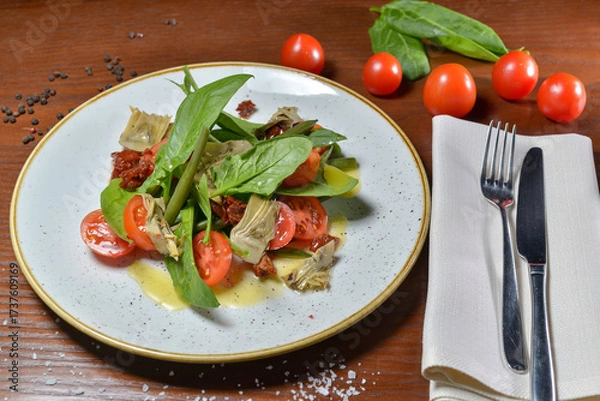 Fototapeta fresh salad with tomatoes and spinach on a table with food decor