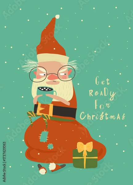 Fototapeta Funny Angry Santa Claus sitting on Bag with Gifts and drink Cocoa