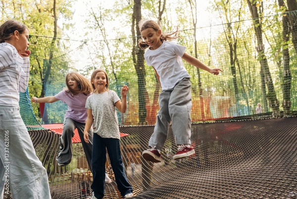 Obraz Weekend activities, fun. Kids are playing on the children's amusement ropes course