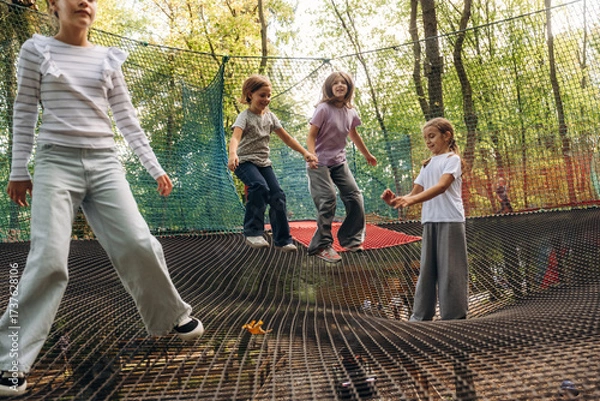 Obraz Weekend activities, fun. Kids are playing on the children's amusement ropes course