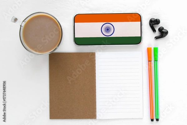 Fototapeta Study workspace with notebook, pens, coffee, smartphone with indian flag on screen, concept of education, hindi language learning and culture