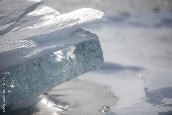 Fototapeta Thick translucent ice slab covered with snow.