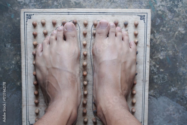 Obraz A Relaxing Foot Massage Experience with an Acupressure Wooden Board