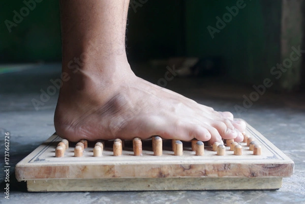 Obraz A Relaxing Foot Massage Experience with an Acupressure Wooden Board