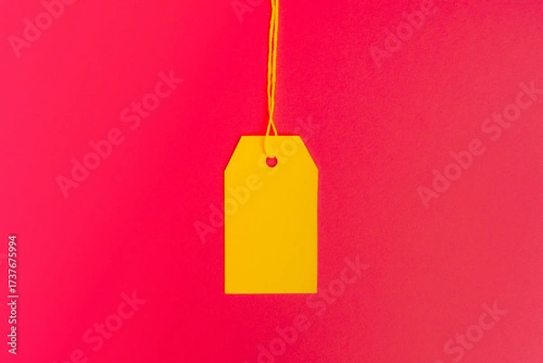 Fototapeta Centered yellow price tag on pink background with copy space. High quality photo