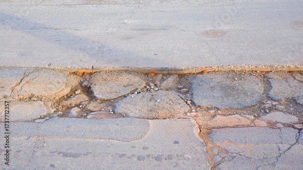 Fototapeta The old badly damaged concrete road background with collapsed and broken crack texture on surface