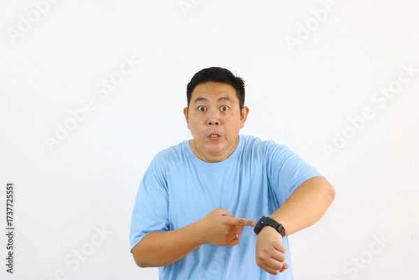 Fototapeta Man Pointing at Watch Looking Concerned About Time