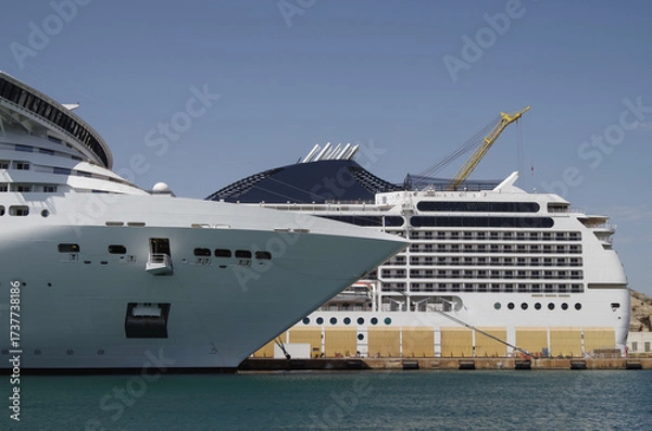 Fototapeta Modern cruise ship cruiseship liner being modernized over-hauled repaired refitted maintenanced by shipyard in Malta with dock and cranes