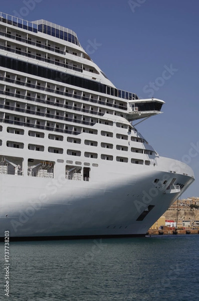 Fototapeta Modern cruise ship cruiseship liner being modernized over-hauled repaired refitted maintenanced by shipyard in Malta with dock and cranes