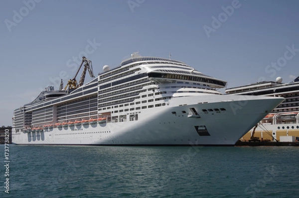Fototapeta Modern cruise ship cruiseship liner being modernized over-hauled repaired refitted maintenanced by shipyard in Malta with dock and cranes