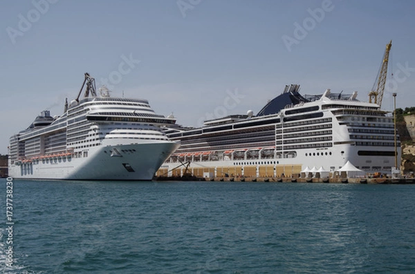 Fototapeta Modern cruise ship cruiseship liner being modernized over-hauled repaired refitted maintenanced by shipyard in Malta with dock and cranes