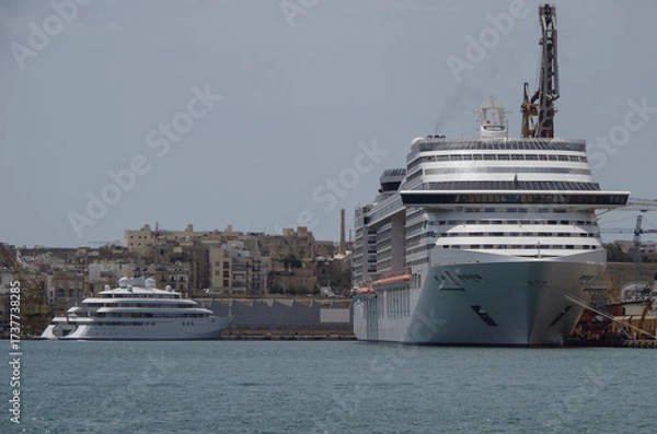 Fototapeta Modern cruise ship cruiseship liner being modernized over-hauled repaired refitted maintenanced by shipyard in Malta with dock and cranes