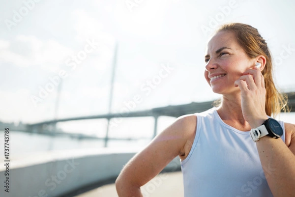 Fototapeta Fitness enthusiast enjoying a run by the river with joyful expression