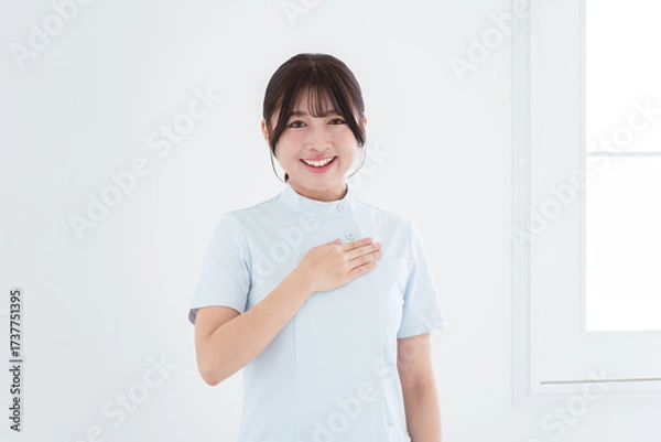 Obraz 胸に手を当てる笑顔の女性看護師