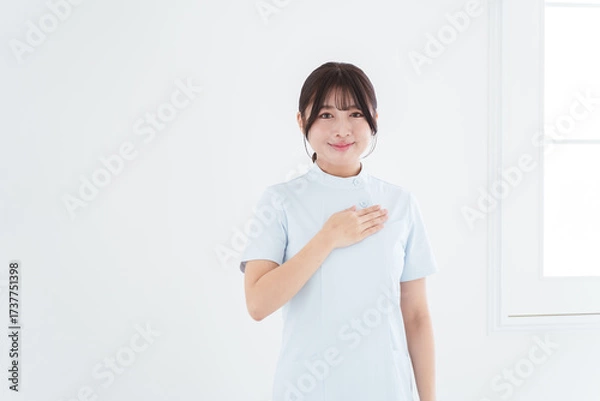Obraz 胸に手を当てる笑顔の女性看護師