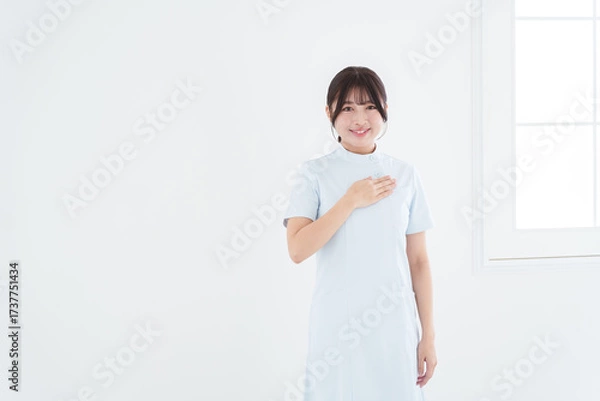 Obraz 胸に手を当てる笑顔の女性看護師