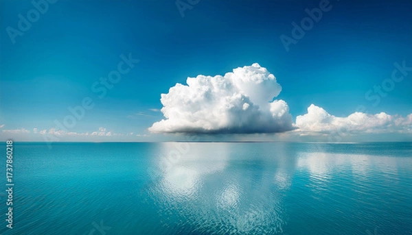 Fototapeta A Large Fluffy Cloud Floats Above Calm Turquoise Water Reflecting The Sky And Clouds