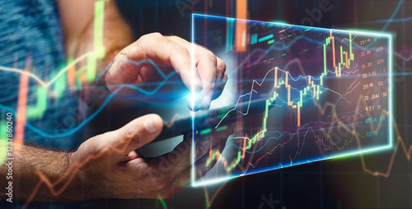 Fototapeta a mano conecta con datos financieros digitales: análisis, decisión y tecnología en tiempo real.Persona toca pantalla de tablet, gráficos financieros holográficos, fondo abstracto con luz y datos.