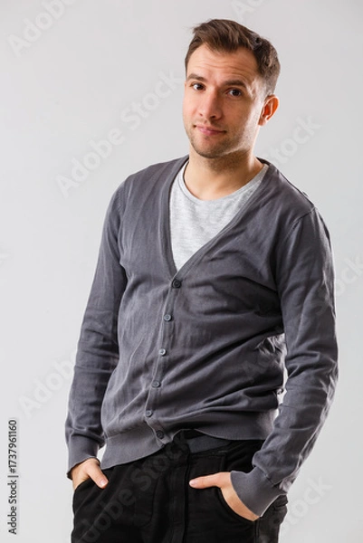 Fototapeta Confident and stylish. young man and looking at camera while standing against white background