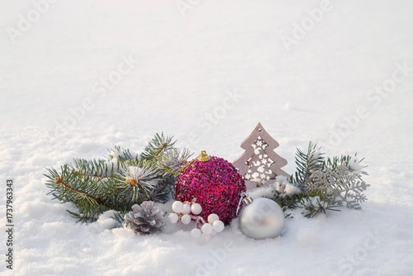 Fototapeta Christmas decorations and fir branches in fluffy snow. Copy space