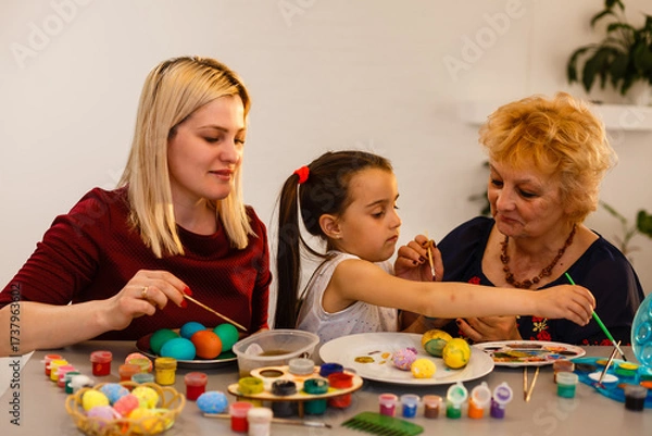 Fototapeta grandmother with granddaughter play with easter eggs, easter time to paint eggs.