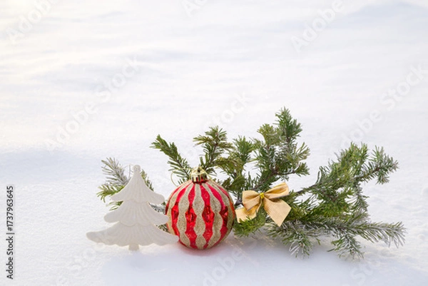 Fototapeta Christmas decorations and fir branches in fluffy snow. Copy space