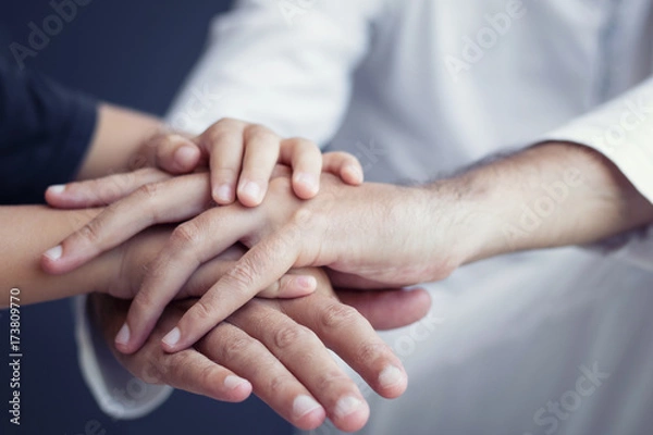 Fototapeta Close-up of boy and child holding hand and supporting each other. Father and son bonds.