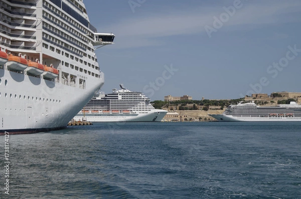 Fototapeta Modern cruise ship cruiseship liner being modernized over-hauled repaired refitted maintenanced by shipyard in Malta with dock and cranes