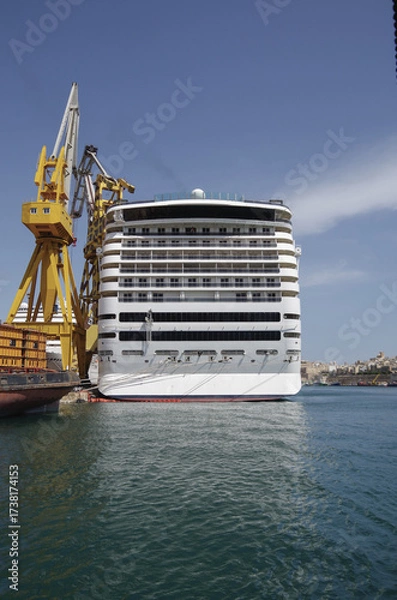 Fototapeta Modern cruise ship cruiseship liner being modernized over-hauled repaired refitted maintenanced by shipyard in Malta with dock and cranes