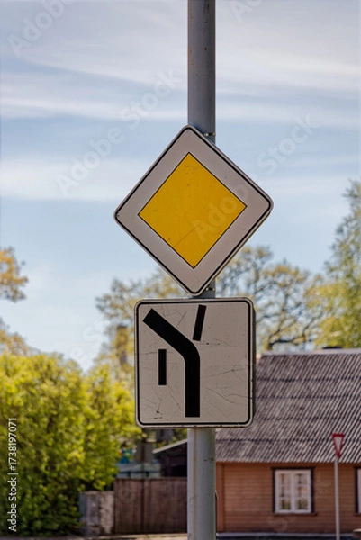Fototapeta European Priority Road Sign Showing Main Road Turning Left Upwards with Side Roads Straight and Down