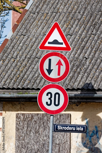 Fototapeta European Road Signs on Skroderu Iela Indicating Bump Ahead, Oncoming Traffic Priority and Speed Limit 30