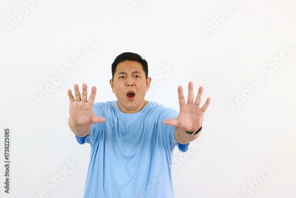 Fototapeta Surprised man gesturing no with hands in front of a white background