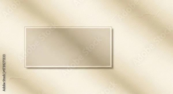 Fototapeta A beige rectangular frame on a beige textured wall with a shadow of a tree branch.