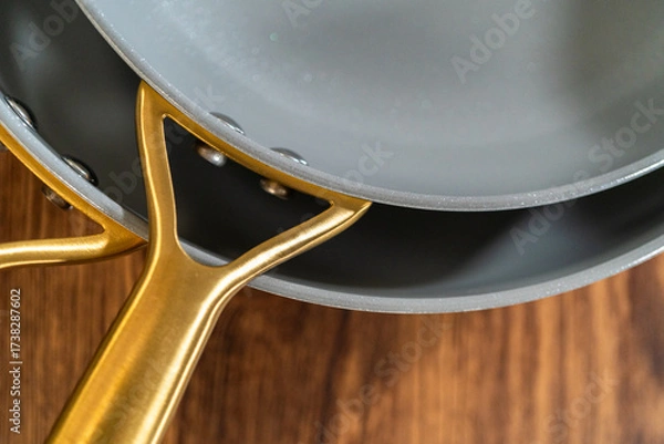 Fototapeta Overhead view of stacked gold-handled pans