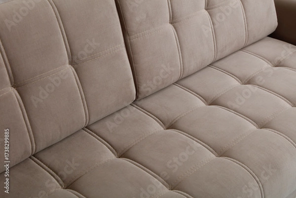 Fototapeta a close up of a beige sofa with tufted upholstery and neatly stitched square patterns.