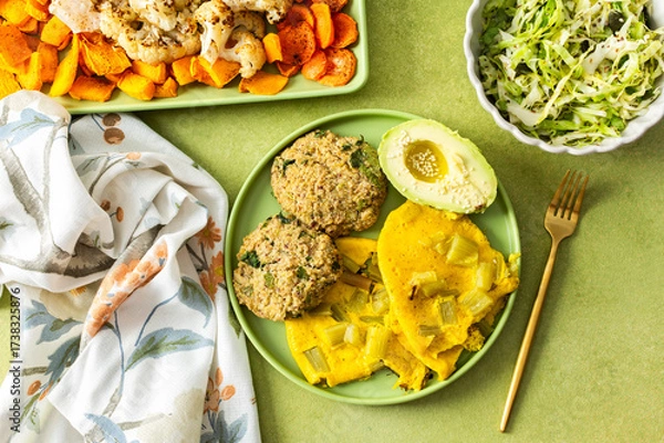 Fototapeta Enjoy a vibrant breakfast featuring scrambled eggs with rhubarb, fluffy quinoa pancakes, creamy avocado drizzled with olive oil, roasted vegetables, and a refreshing fresh salad