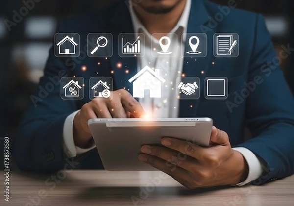 Fototapeta Man in suit using tablet with real estate icons floating above the screen in a blurred setting