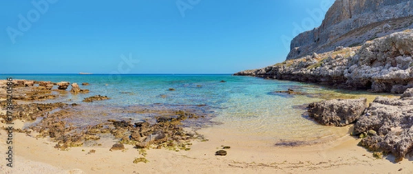 Obraz Sun shines on wet sand and rocks at Navarone Bay, Rhodes island, nice remote beach