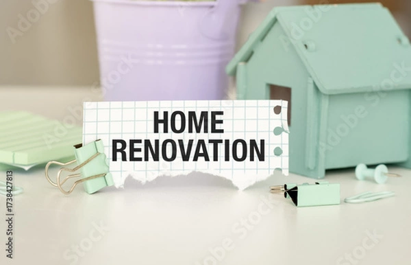 Fototapeta A sign that says Home Renovation is on a table. There are also some hose and a potted plant in the background