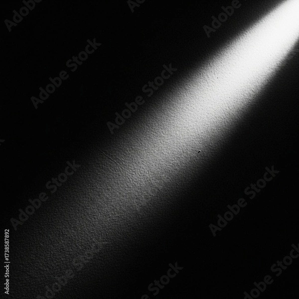 Fototapeta A beam of light shining on a dark wall, creating a stark contrast.