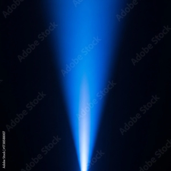 Obraz A vibrant blue light beam shines upwards from a dark background, creating a dramatic and ethereal effect with a soft glow.