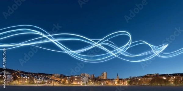 Fototapeta Luminograffiti pattern drawn by drones above a modern city skyline at night under clear blue sky