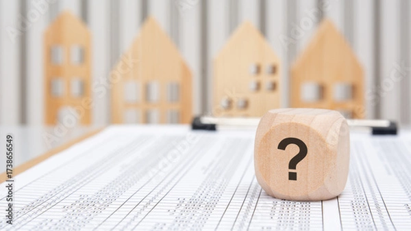 Fototapeta wooden cube with question mark on financial table with houses