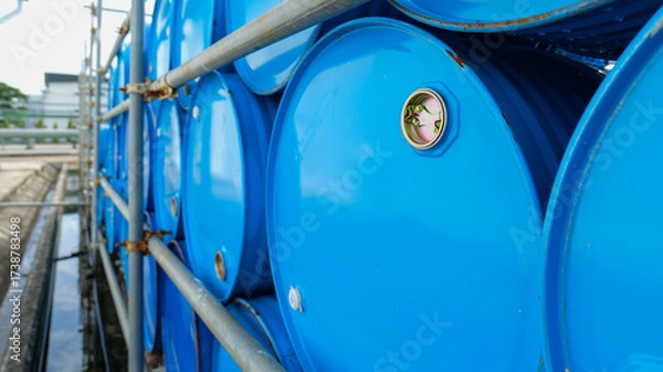 Fototapeta Stacked chemical storage tanks arranged in multiple layers in a storage yard at a chemical factory, representing industrial safety,