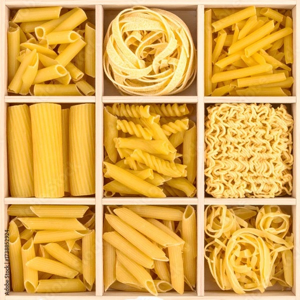 Obraz Various pasta shapes, including penne, rigatoni, fusilli, and fettuccine, are arranged in a wooden box, providing a visually appealing presentation of different culinary options.