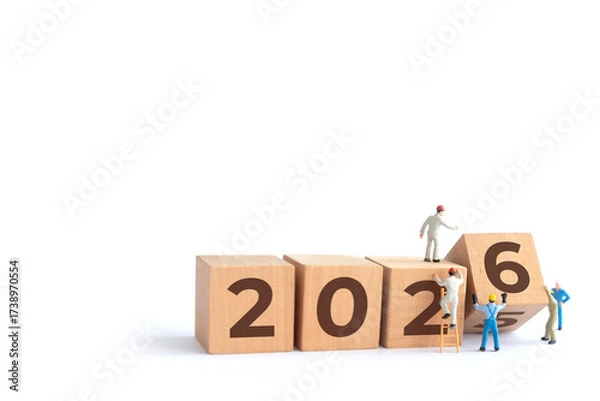 Fototapeta Transitioning from 2025 to 2026 with wooden blocks and miniature people. new year 2026 concept with white background.